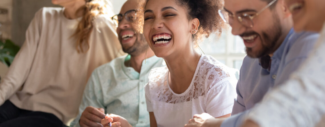 A diverse group of people laughing and engaging in a supportive discussion, representing the positive effects of DBT skills for depression in improving emotional well-being and relationships.