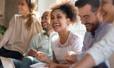 A diverse group of people laughing and engaging in a supportive discussion, representing the positive effects of DBT skills for depression in improving emotional well-being and relationships.