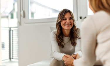 Smiling woman, talking to psychologist, feeling positive about treatment options for depression