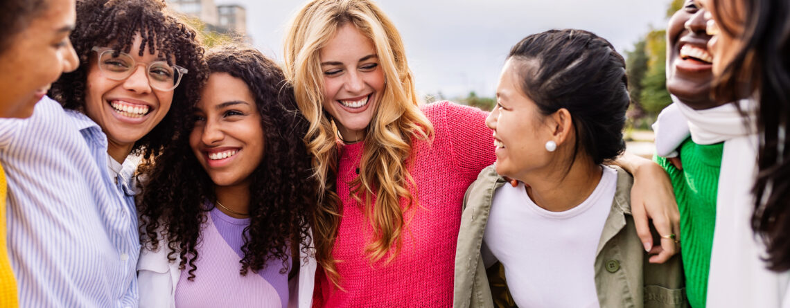 girl friends hugging each other and laughing practicing skills that demonstrate how to maintain friendships