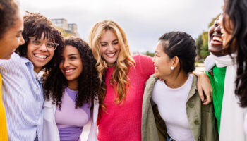 girl friends hugging each other and laughing practicing skills that demonstrate how to maintain friendships