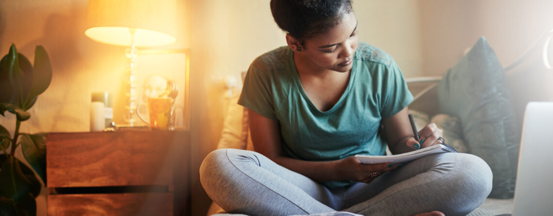 Cropped shot of a young female during her bedtime routine student journaling at home before she goes to bed