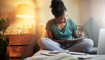 Cropped shot of a young female during her bedtime routine student journaling at home before she goes to bed